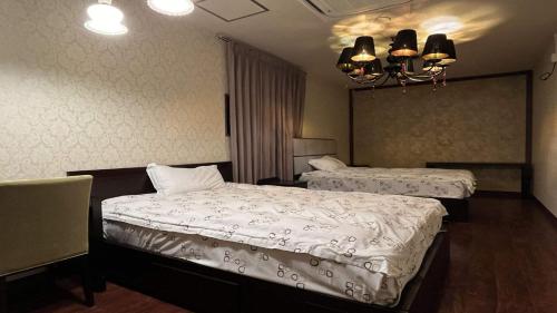 a hotel room with two beds and a chandelier at Harriway Hotel Hakone in Hakone