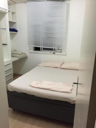 a small bedroom with a bed with a window at Quarto no posto 5 de Copacabana in Rio de Janeiro