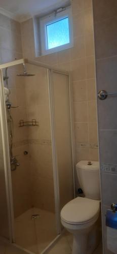 a bathroom with a toilet and a shower with a window at La Casa de Oludeniz, Fethiye in Fethiye