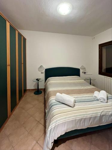 a bedroom with a bed with two towels on it at Villa Aurelia - Pool, BBQ & Tennis Court - San Teodoro in San Teodoro