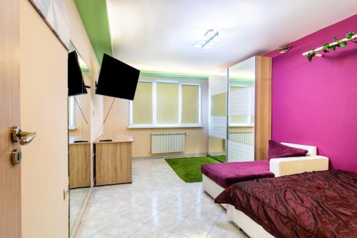 1 dormitorio con paredes de color púrpura, 1 cama y TV en The Right Choice 9, en Sofía
