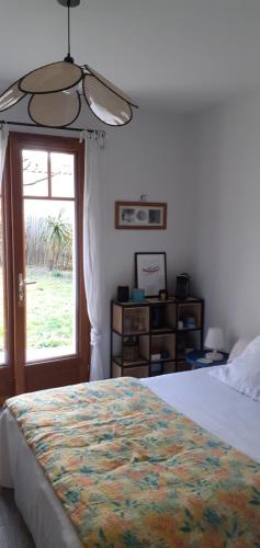 a bedroom with a large bed and a window at Dépendance in Lège-Cap-Ferret