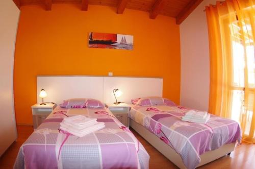 2 camas en una habitación con paredes de color naranja en Ferienhaus in Vodnjan mit Privatem Pool, en Vodnjan