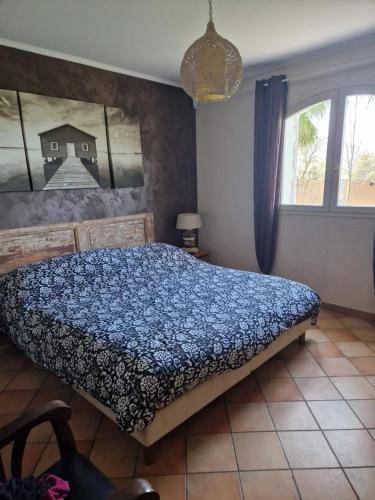 une chambre avec un lit avec une couette bleue dans l'établissement Le Mas Cesylae, à Carqueiranne