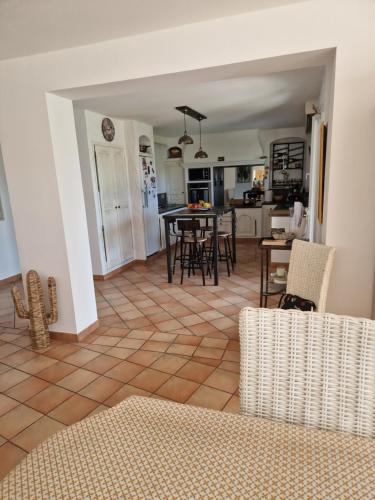 une cuisine et un salon avec une table et des chaises dans l'établissement Le Mas Cesylae, à Carqueiranne