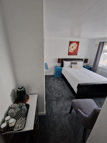 een slaapkamer met een bed, een tafel en een stoel bij Beck's Sunset Accommodation in Dover