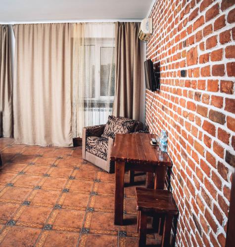 a living room with a brick wall and a table at Fortetsya "Стабільне електропостачання!" in Umanʼ
