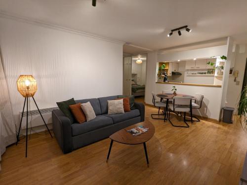 ein Wohnzimmer mit einem Sofa und einem Tisch in der Unterkunft Vista Linda, leuk appartement vlak bij zeedijk en strand in Ostende