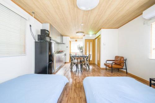 two beds in a room with a kitchen and a table at Premier suite Yoyogi front detached house in Tokyo