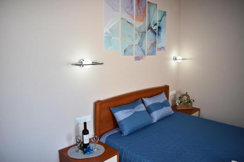 a bedroom with a bed with blue sheets and blue pillows at Venice Apartments 2 in Limenaria