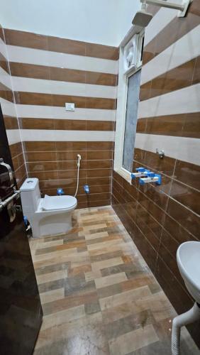 a bathroom with a toilet and a sink at Hotel Shri kishori farm in Mathura