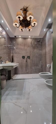 a bathroom with a shower and two sinks and a chandelier at Relais I Due Roccoli in Iseo