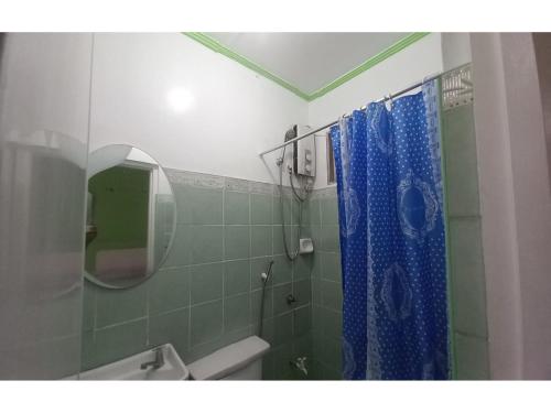 a bathroom with a shower with a blue shower curtain at OYO 1048 Jomckayl Apartelle in Naga