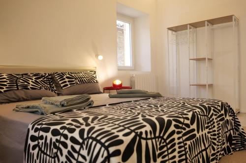 una camera con un letto bianco e nero e una finestra di Maison62 a San Severino Marche