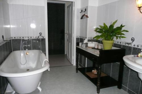 La salle de bains est pourvue d'une baignoire, d'un lavabo et d'une baignoire. dans l'établissement LES TERRES BASSES, à Fabrezan