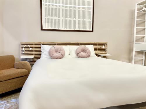 a bedroom with a white bed with pink pillows at Mercadante Suite Central City in Milan