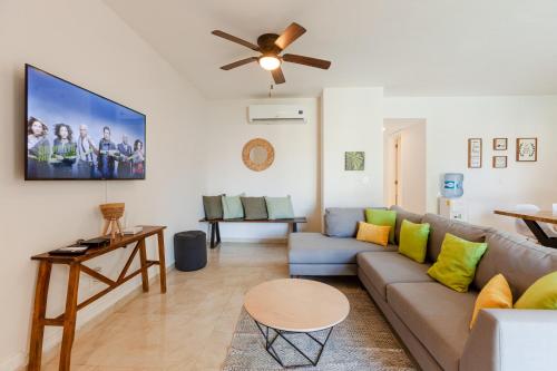 a living room with a couch and a ceiling fan at Via Tendenza Condos in Playa del Carmen