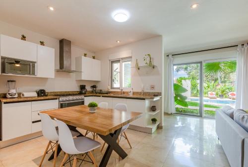 a kitchen and dining room with a wooden table and chairs at Via Tendenza Condos in Playa del Carmen