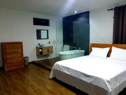 1 dormitorio con 1 cama y baño con bañera en Calodyne residence en Grand Gaube