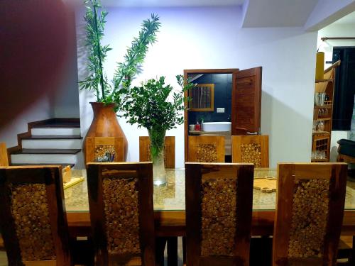 a dining room with a table and chairs with plants at Calodyne residence in Grand Gaube