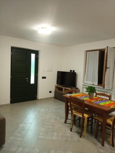 - un salon avec une table et une porte noire dans l'établissement Colli di Luni, à Luni