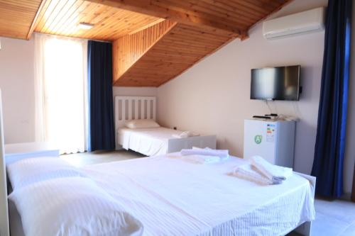 a bedroom with a white bed and a tv at La Sorella in Dalyan
