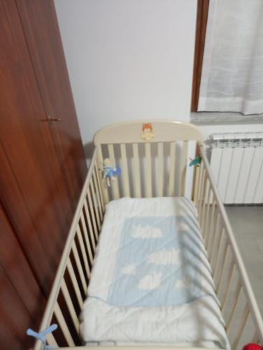 a crib in a room next to a door at Colli di Luni in Luni