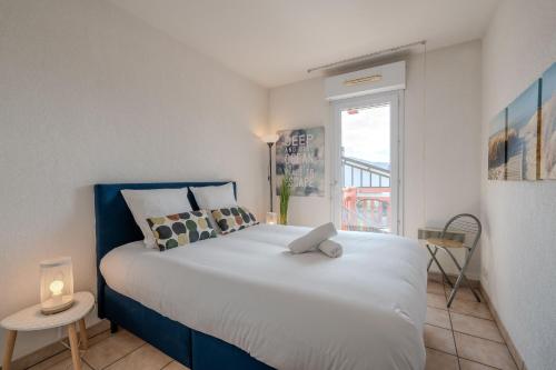 a bedroom with a large white bed with a window at Atlantic Selection - Charmant & calme avec piscine et parking in Hendaye