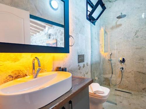 a bathroom with a sink and a toilet and a mirror at Villa NazlıSu in Kaş