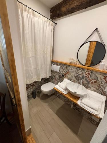 y baño con lavabo, aseo y espejo. en B&B Casa Doria en Castelsardo