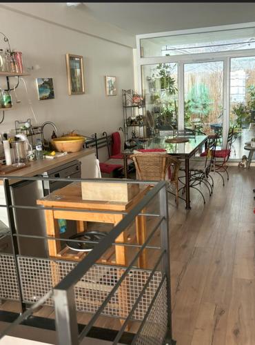 une cuisine et une salle à manger avec une table et des chaises dans l'établissement La Maison d’Aromarie, à Tournus