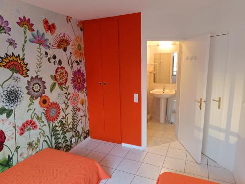 La salle de bains est pourvue d'une porte rouge et d'un lavabo. dans l'établissement Your holiday Island in Mandelieu-la-Napoule, à Mandelieu-la-Napoule