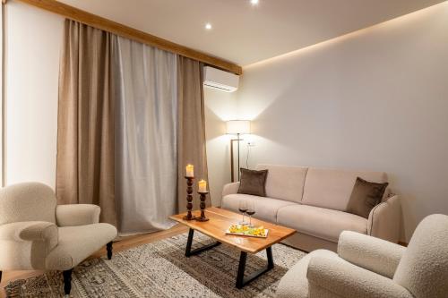 ein Wohnzimmer mit einem Sofa, 2 Stühlen und einem Tisch in der Unterkunft Likoria Hotel in Arachova