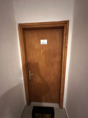 a wooden door with a sign on it in a room at Pansion Angela in Skiathos Town