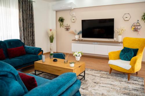 un soggiorno con un divano e una TV di Olivia Apartment a Sarandë