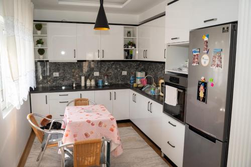 kuchnia ze stołem i lodówką w obiekcie Olivia Apartment w Sarandzie