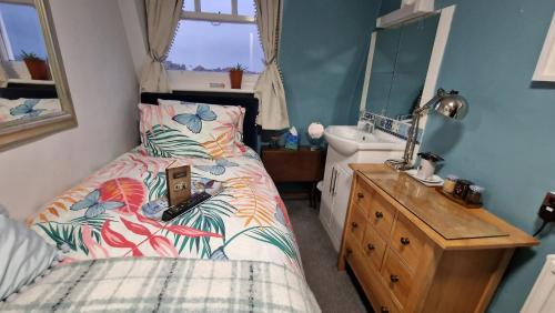 a small bedroom with a bed and a sink at The Ocean Guest House in Weymouth