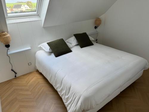 Cette chambre comprend un grand lit blanc et une fenêtre. dans l'établissement Apparthôtel Mont Saint Michel - Résidence Fleurdumont, à Beauvoir