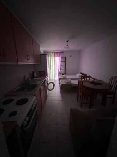 a kitchen and living room with a table and a couch at Pansion Angela in Skiathos Town
