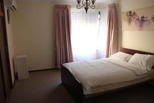 1 dormitorio con 1 cama grande y ventana en Comfort and Convenient en Perth