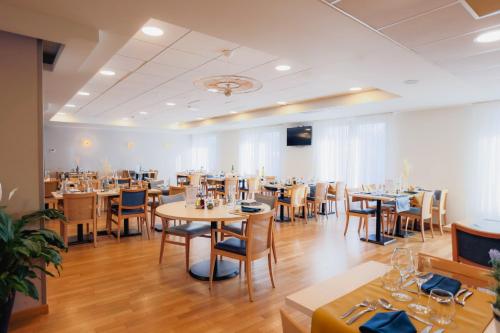 バイユーにあるドミティシ レ ファラズ ブロンシュの広い客室で、レストラン内のテーブルと椅子が備わります。