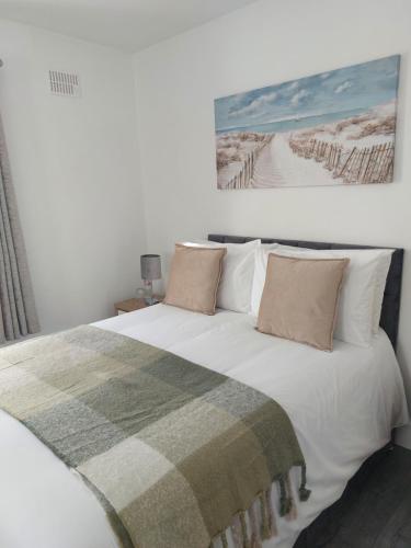 a bedroom with a white bed with a blanket on it at Mountain Aven Guest House in Doolin
