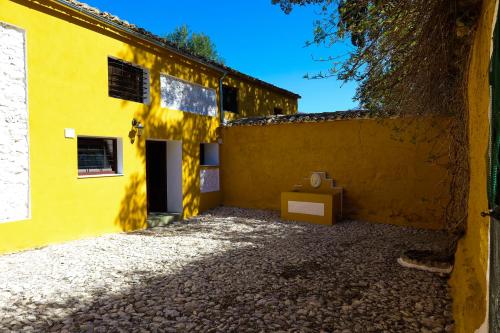 un edificio amarillo con una caja delante en Casa rural el Ayozar, en Albanchez de Úbeda