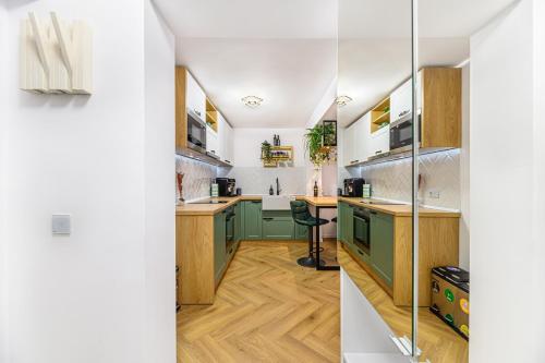 a kitchen with green cabinets and wooden floors at Studio Guapo in Poiana Brasov