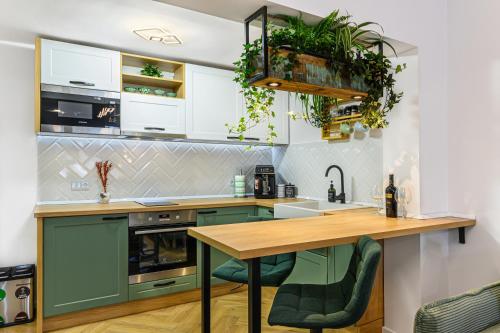 a kitchen with green cabinets and a wooden table at Studio Guapo in Poiana Brasov