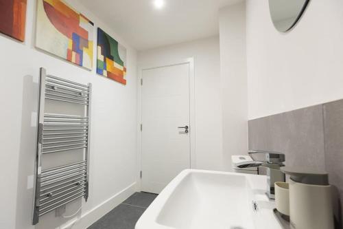 Baño blanco con bañera y lavamanos en PAPER MILL - Experience the city and nature side of this stay! en Sheffield