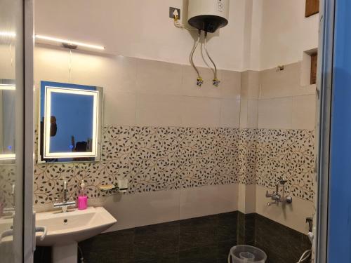 a bathroom with a sink and a mirror at Abhi's Cottage in Mukteswar