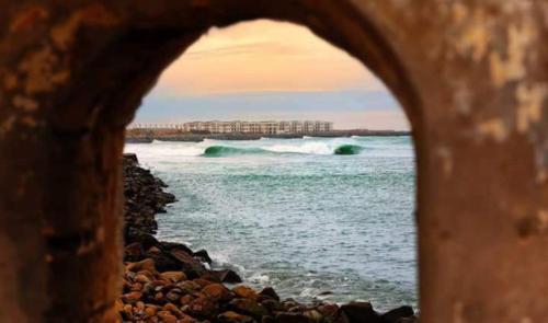 a view of the ocean through a stone archway at Mehdia beach one in Kenitra