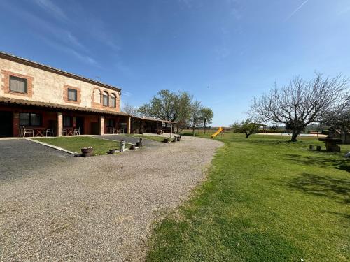 ein Gebäude mit einem Rasenplatz neben einem Gebäude in der Unterkunft Can Pujol - Turismo Rural in Serra de Daró