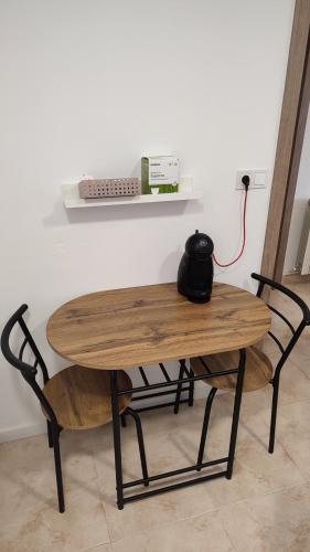 a wooden table and a chair with a tea pot on it at La Quadra de Quelo 3 in Àger
